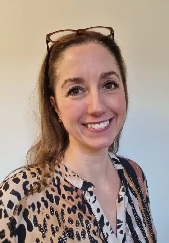 Portræt af jordemoder Rikke Kristensen med et smil og briller på hovedet.