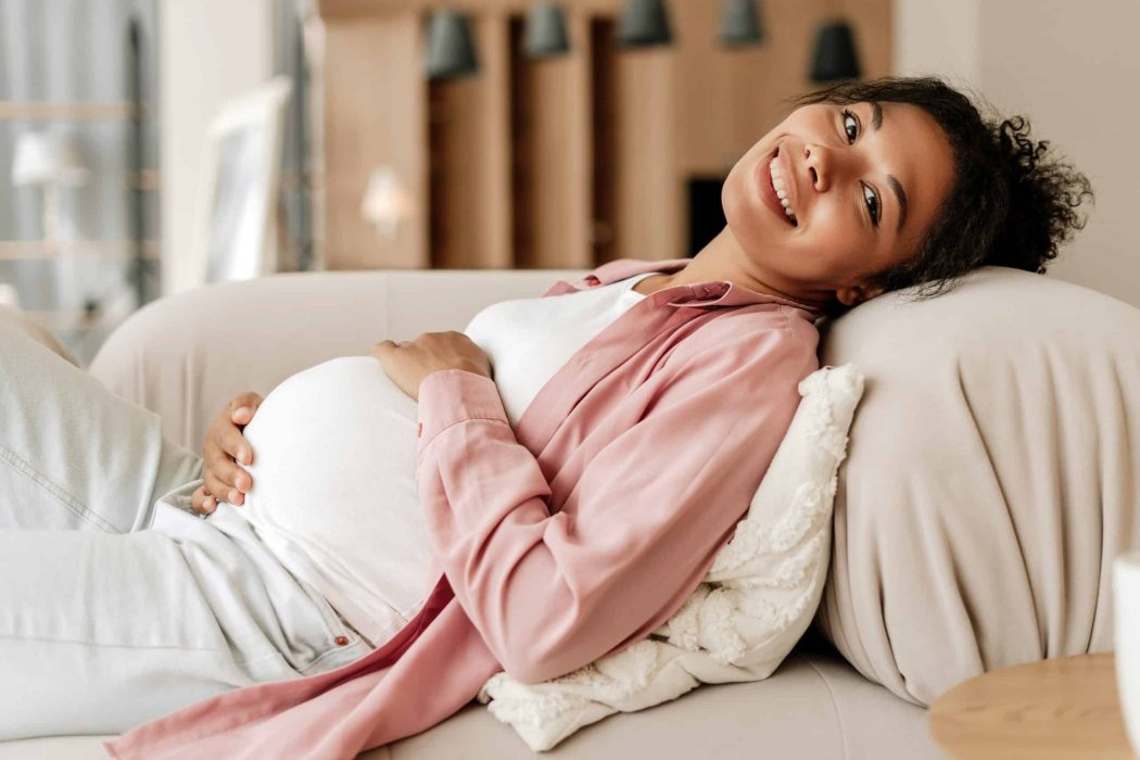 Gravid kvinde slapper af og holder om maven